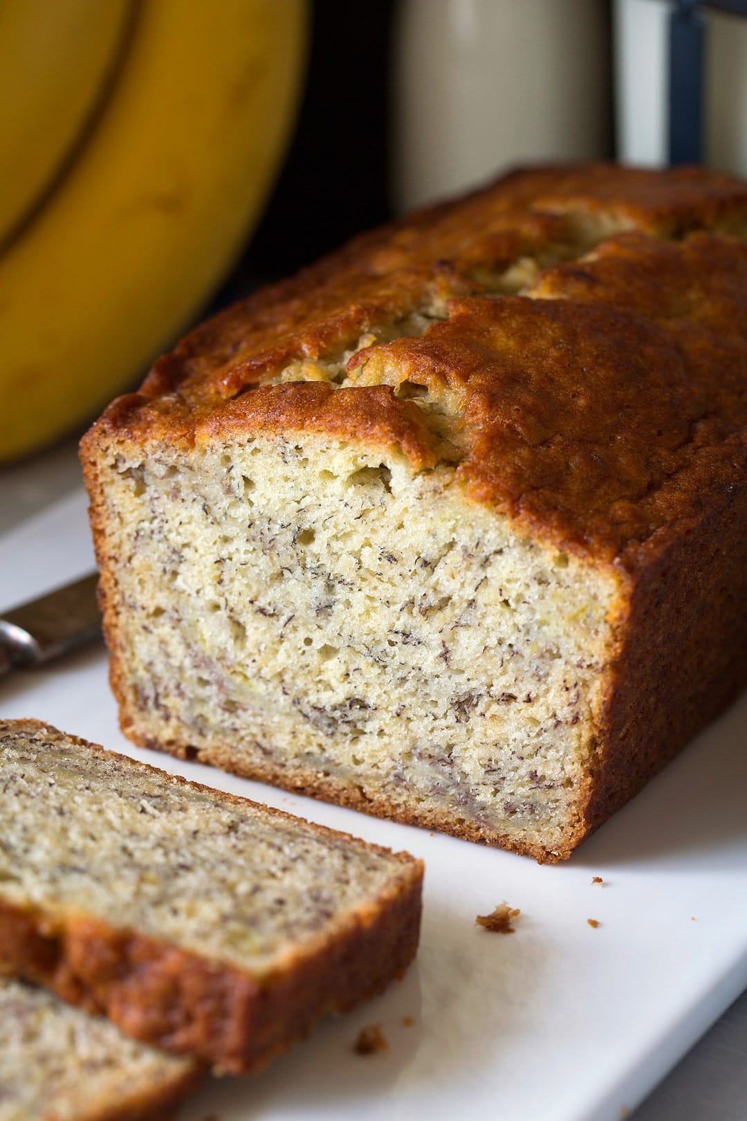 A loaf of homemade banana bread on a white plate