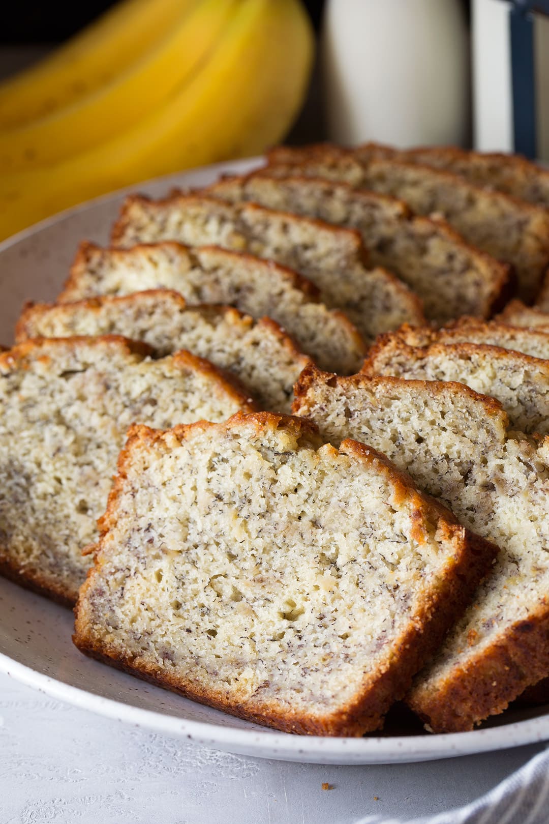 homemade banana bread cut into slices on a large plate