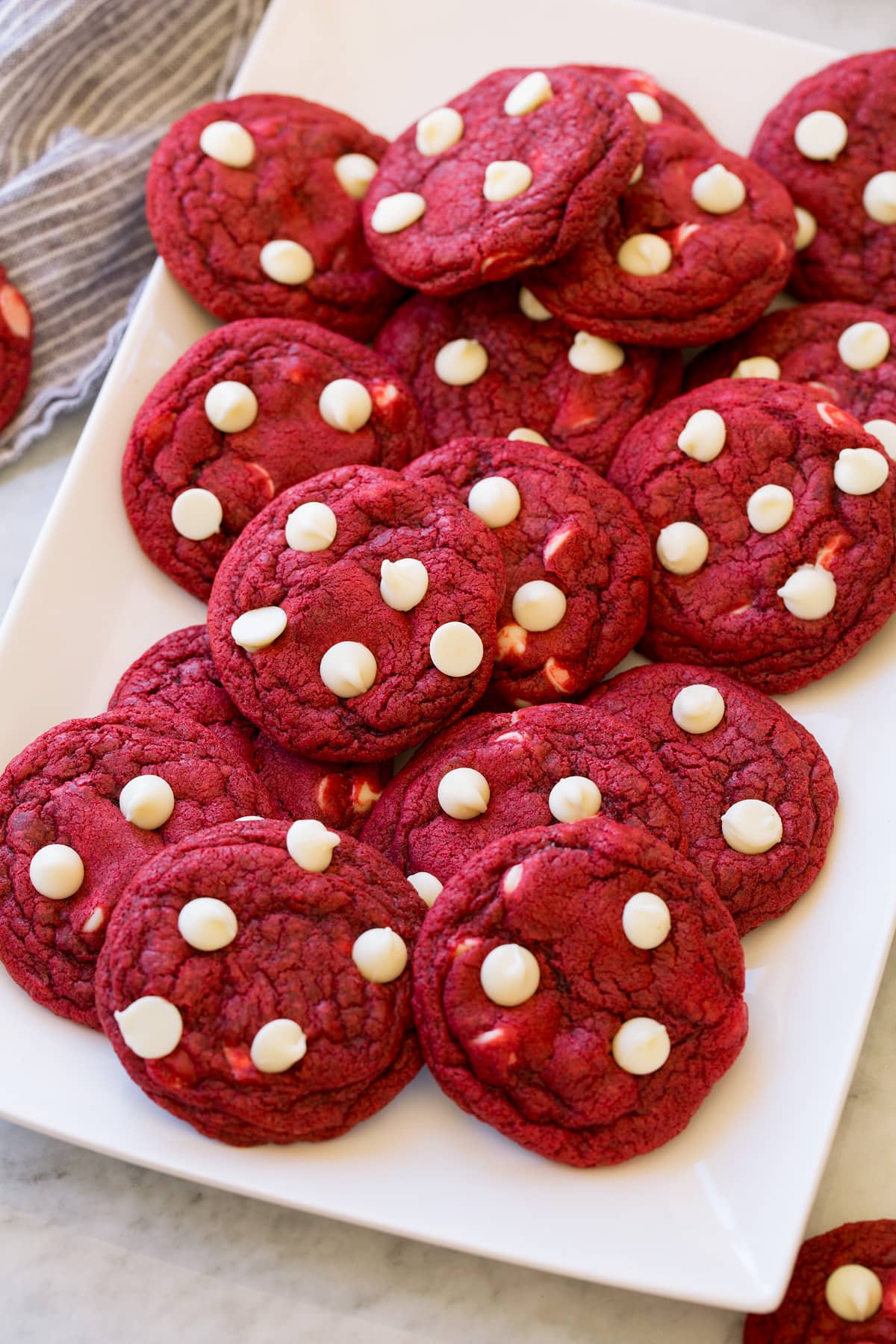 Red Velvet Cookies layered together, shown from a side angle on a platter.
