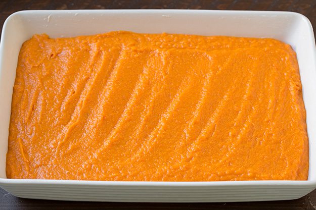 Spreading sweet potatoes into an even layer in baking dish.