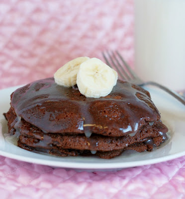Chocolate cake pancakes topped with syrup and bananas