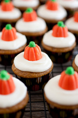 Mini pumpkin cupcakes with cream cheese frosting and pumpkin candy toppers