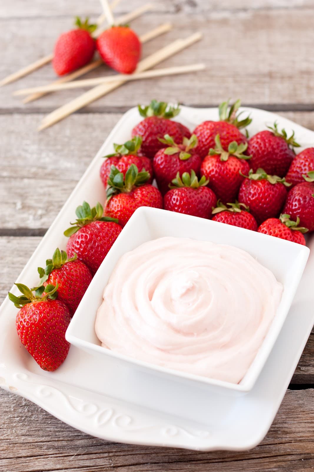 strawberry dip in white bowl on platter with fresh strawberries