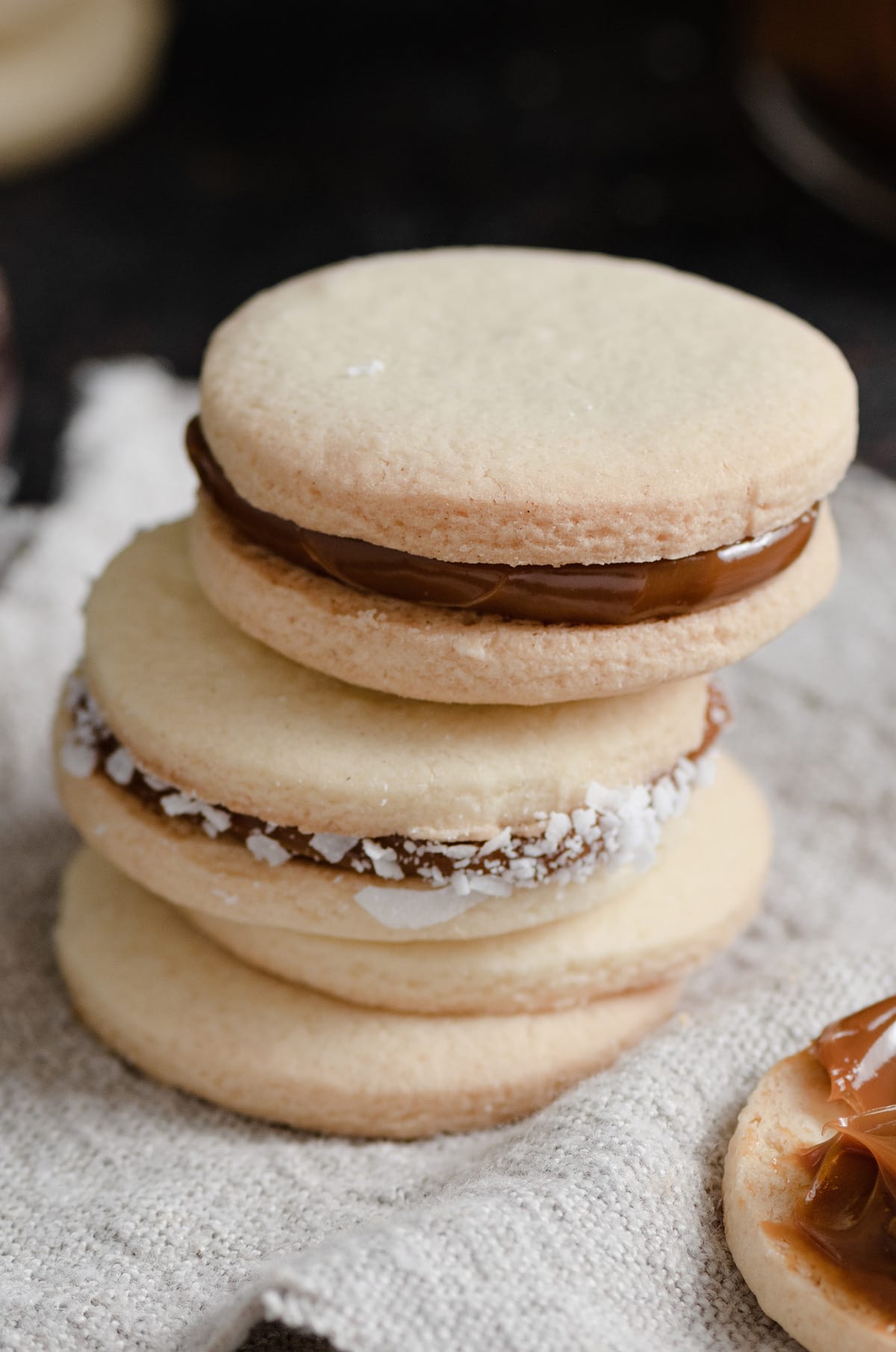 Close up image of stack of dulce de leche filled alfajores sandwich cookies