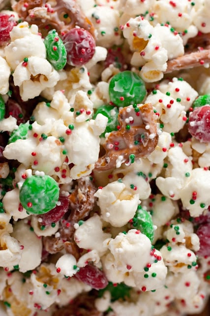 Christmas Crunch. Bring some holiday spirit to your snacks with funfetti popcorn Christmas style! It can be whipped up in only 10 minutes and decorated with as many sprinkles as you like. This popcorn treat is perfect for holiday gifts and parties. | Christmas Recipes | #cookingclassy #snacks #popcorn #funfetti A close up of christmas crunch funfetti popcorn