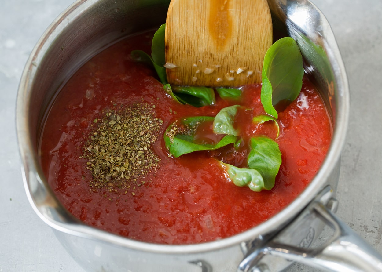 Showing how to make marinara sauce in a stainless steel saucepan for chicken parmesan.