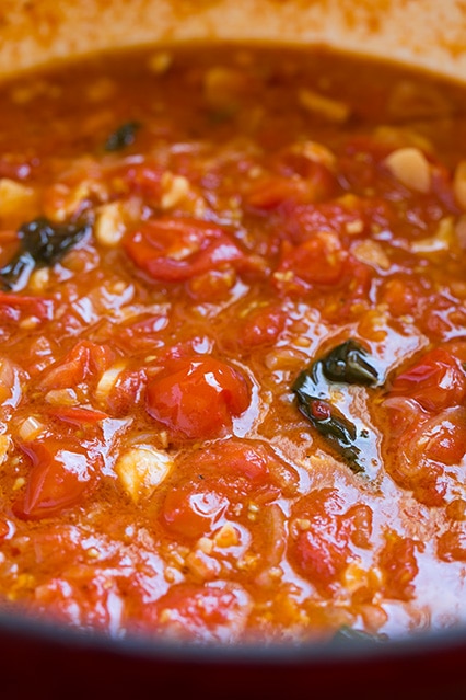 A poached cherry tomato sauce simmering in a pan