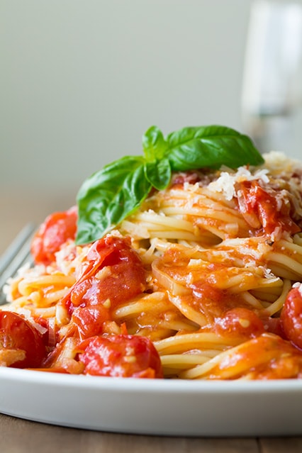 A close up of spaghetti with a cherry tomato sauce