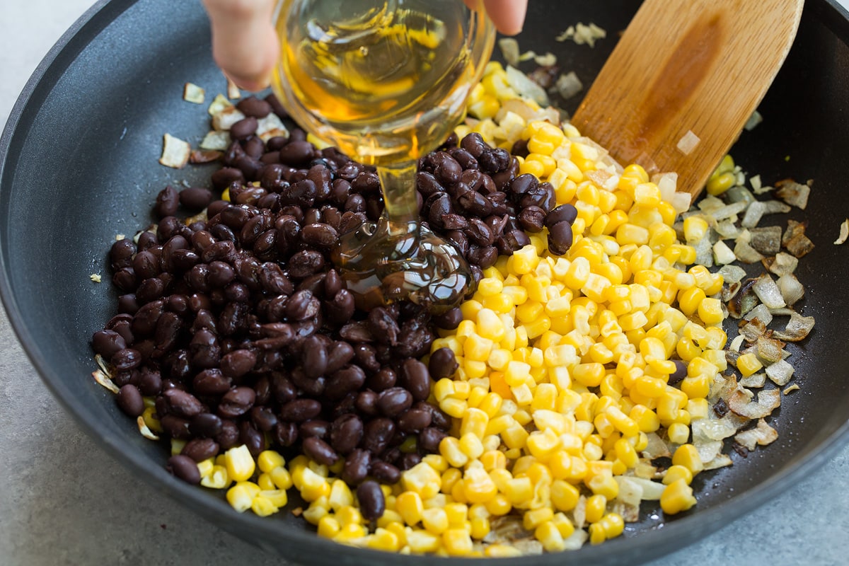 Adding black beans, corn, honey and lime to skillet