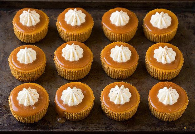 Twelve mini pumpkin cheesecakes. 