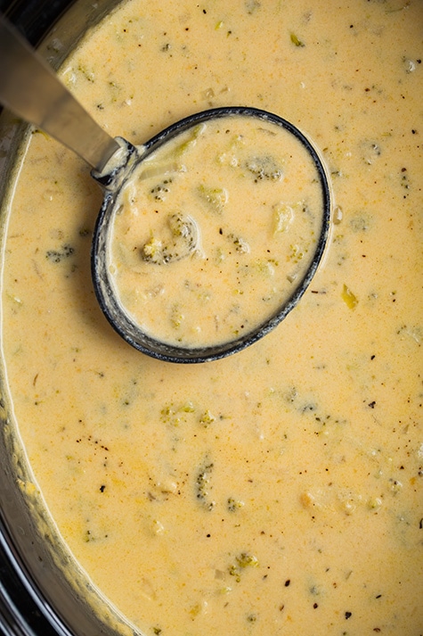 Slow Cooker Broccoli Cheese Soup in a slow cooker with a ladle 