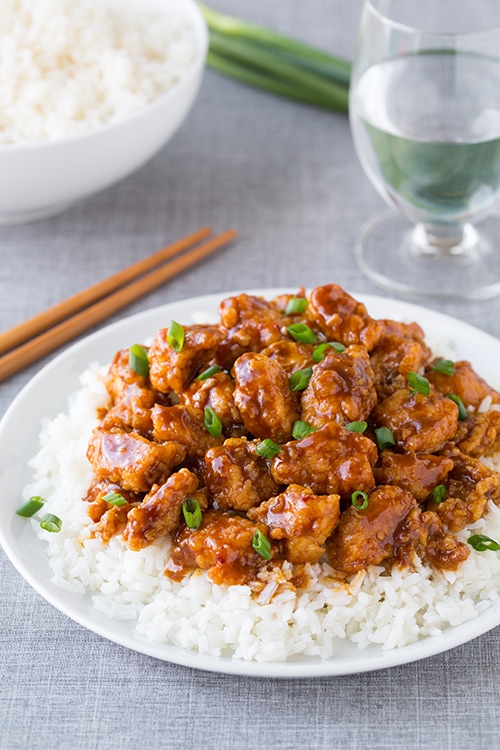 General Tso's Chicken on top of white rice on dinner plate