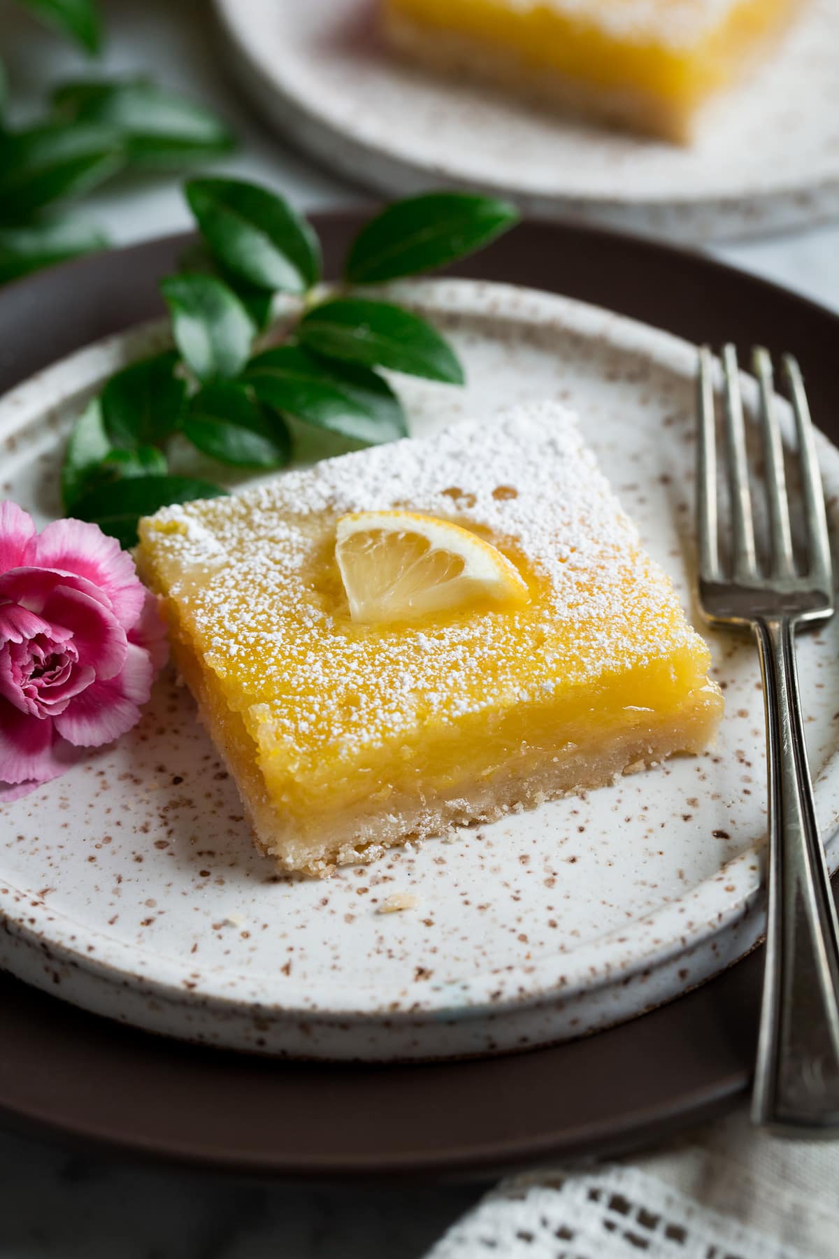 Lemon Bar on white dessert plate with fork 