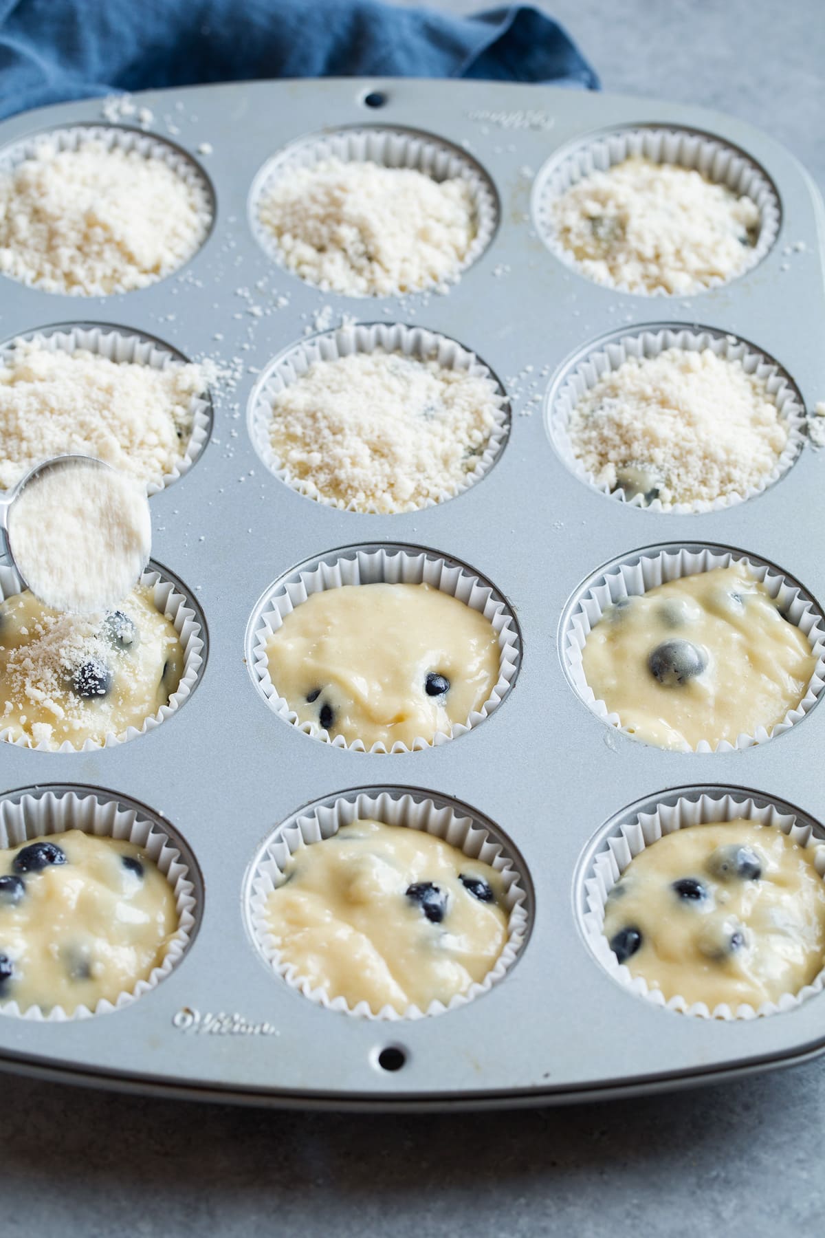 Dividing bluberry muffin batter among 12 muffin cups.