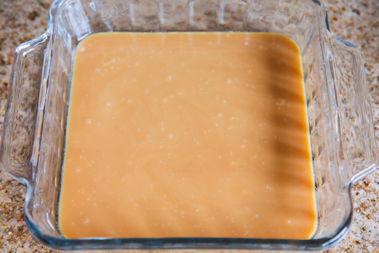Caramel mixture poured into buttered glass baking dish.