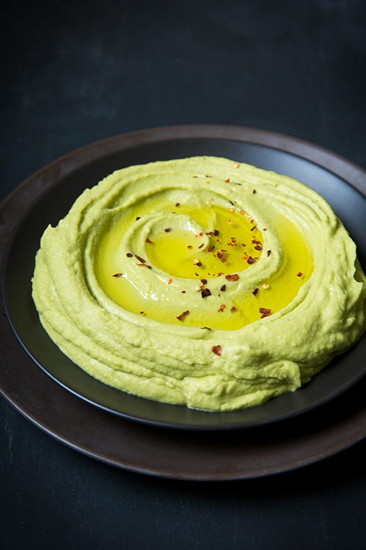 Avocado Hummus in a bowl topped with red pepper flakes