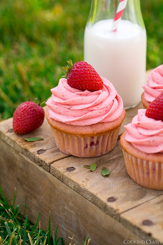 Strawberry Cupcakes on a wooden surface with a glass of milk