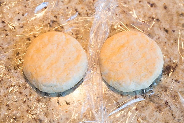 Placing cannoli shell dough on plastic wrap