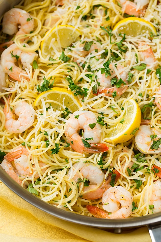 lemon shrimp pasta garnished with lemon wedges in skillet