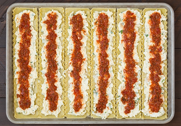 Tomato sauce spread on pasta for making lasagna roll ups