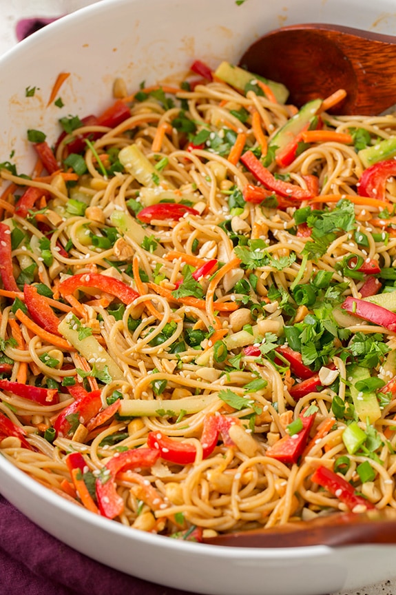 Spicy Thai Peanut Noodles in serving bowl with wooden spoon