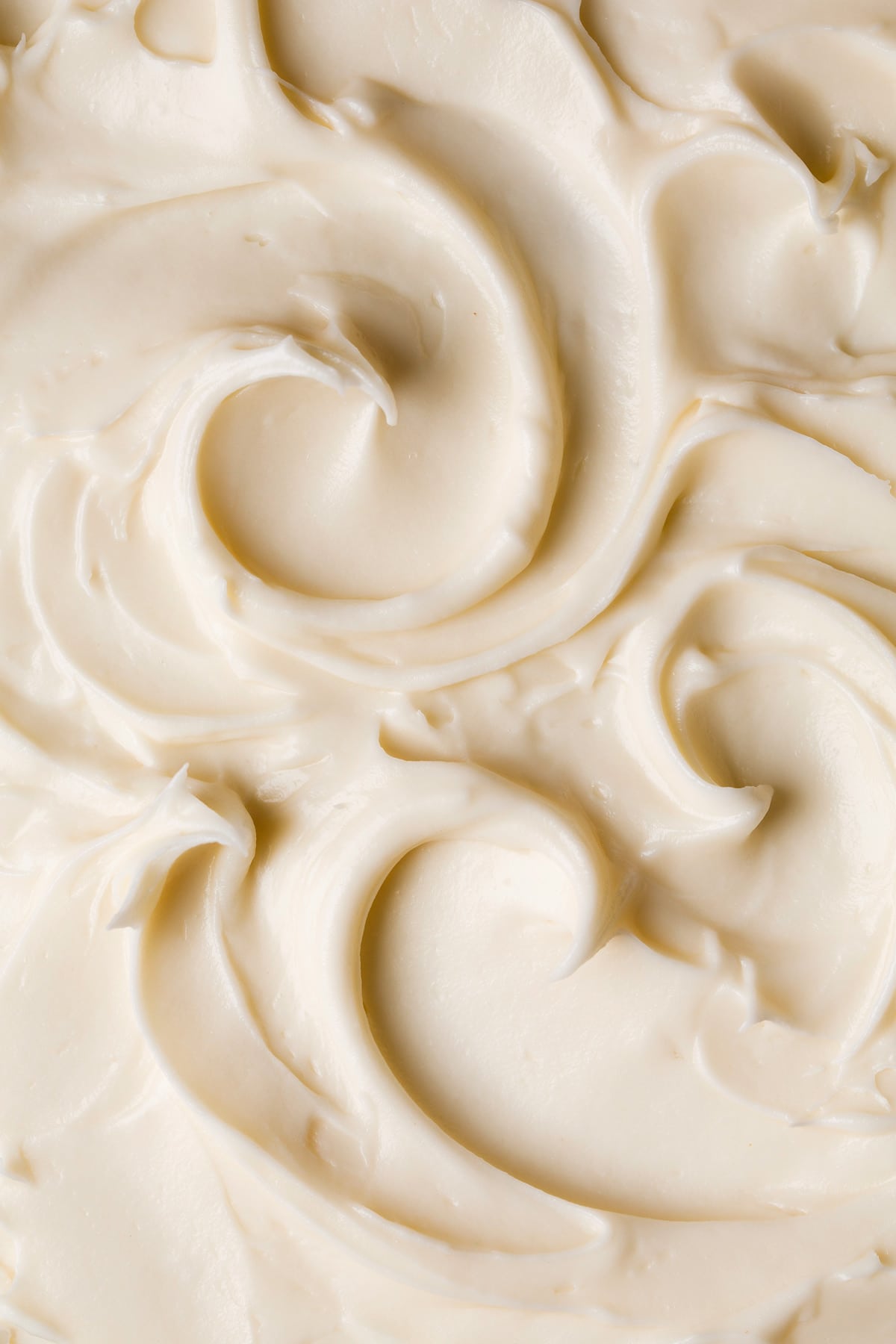 Close up image of cream cheese frosting with pretty swirls.