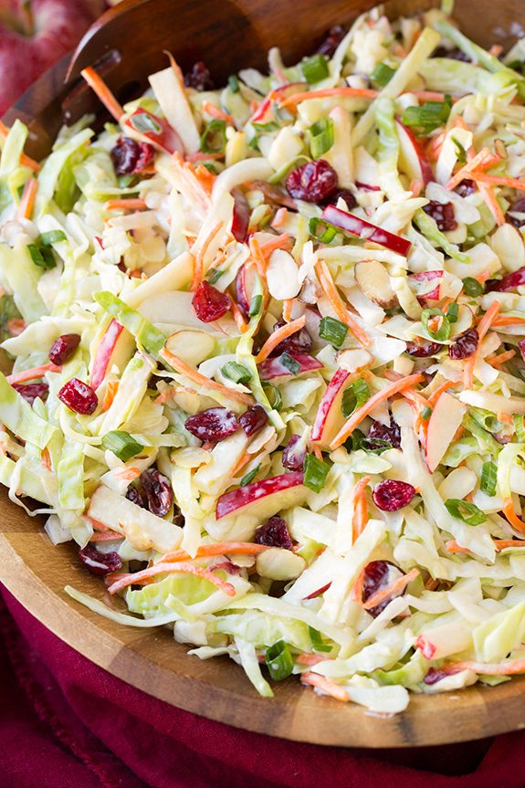 Apple Cranberry Almond Coleslaw in a wooden bowl with a creamy dressing
