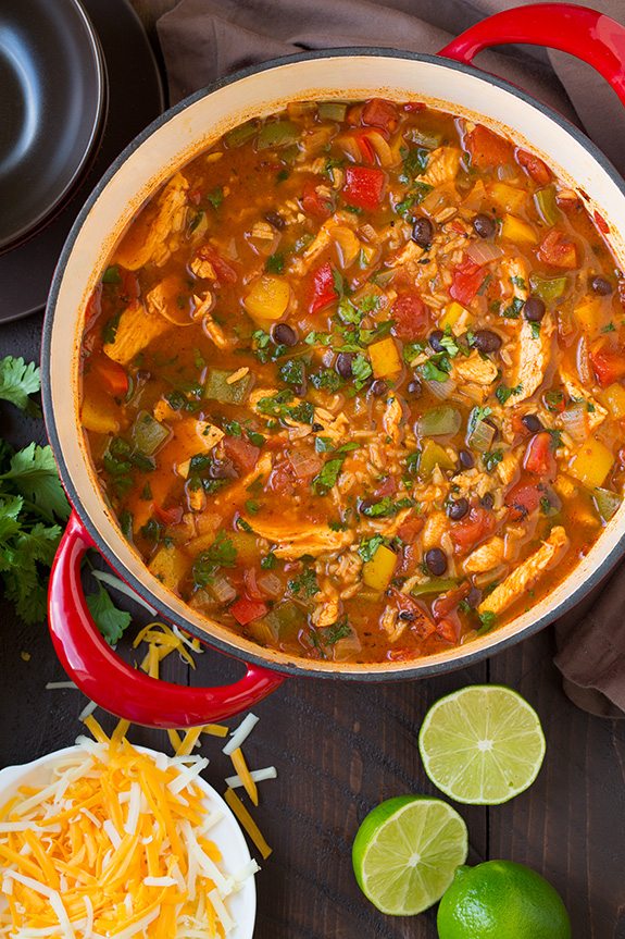 Chicken Fajita Soup on stovetop with lime, cheese and cilantro