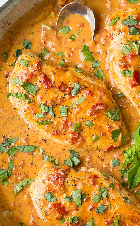 Sun Dried Tomato Chicken toped with basil leaves in plenty of sauce