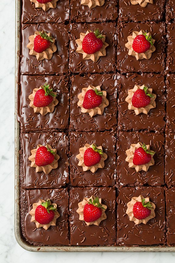 Full pan of chocolate sheet cake topped with bright red strawberries