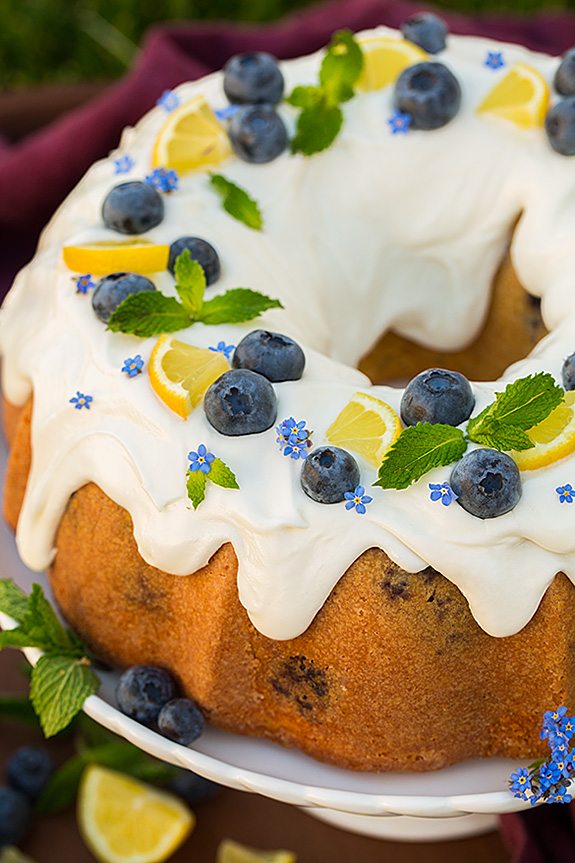 Lemon Blueberry Bundt Cake with Lemon Cream Cheese Icing garnished with fresh blueberries, lemon slices and mint leaves
