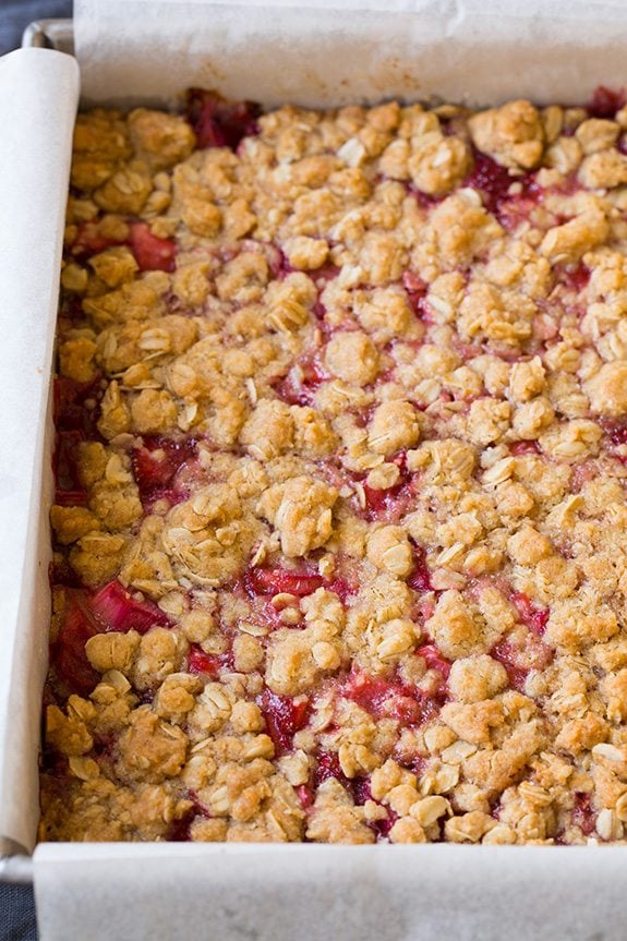 Strawberry Rhubarb Bars in baking dish with parchment paper on the sides