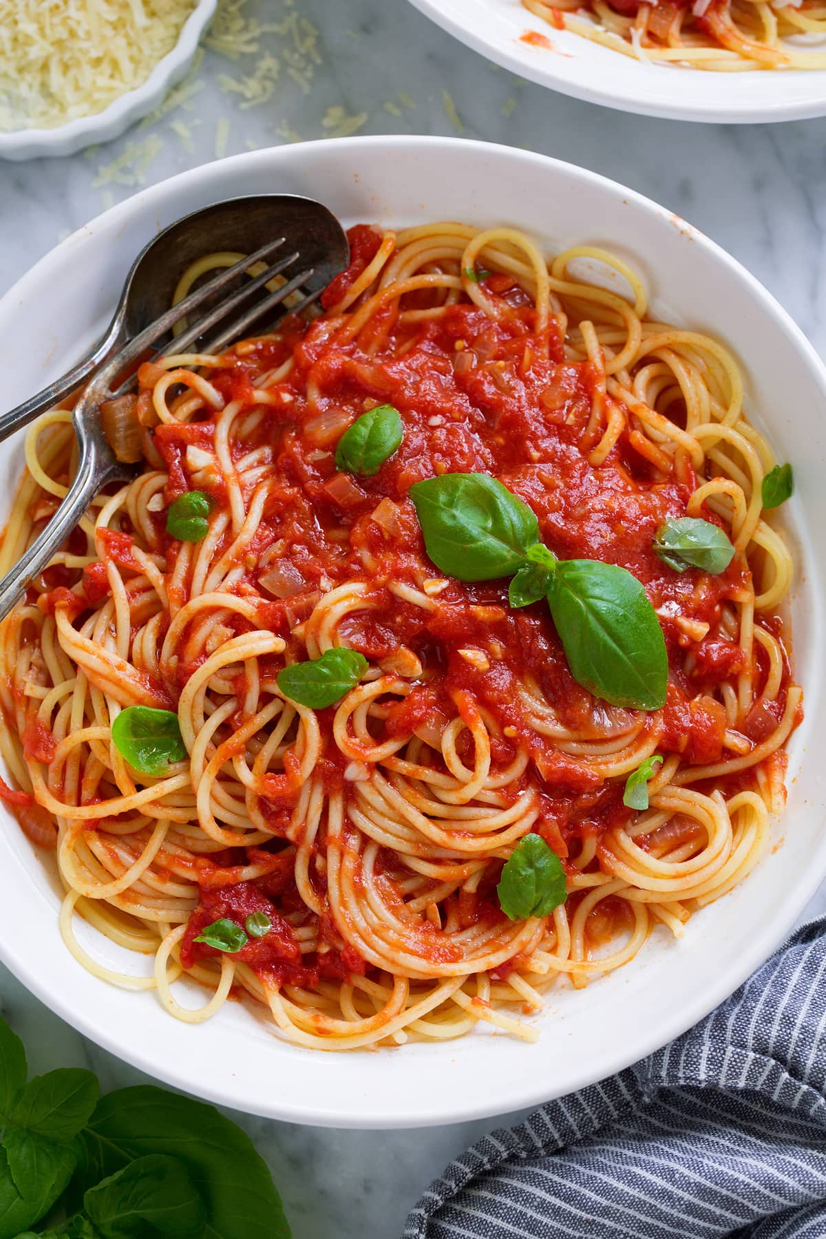 Marinara sauce tossed with spaghetti in a pasta bowl.
