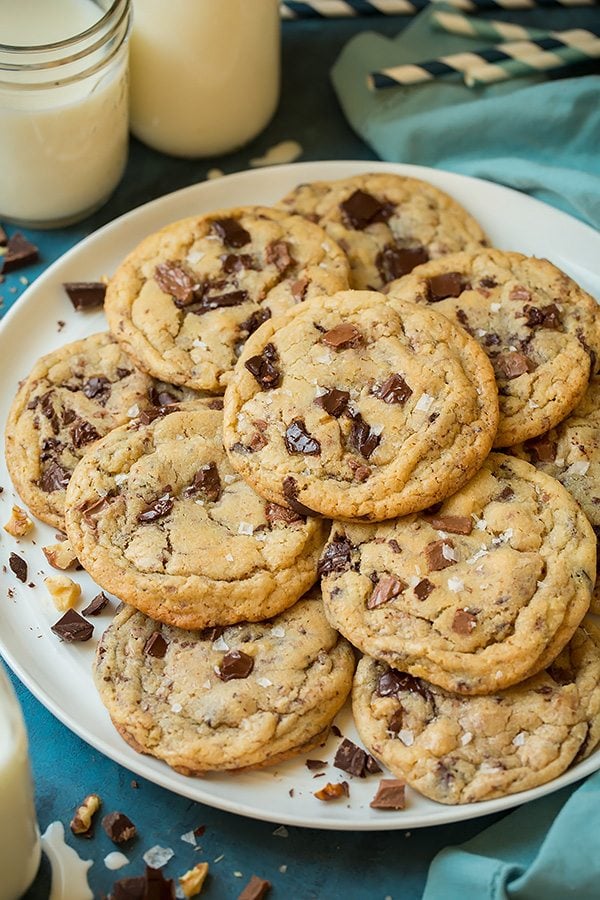 Chocolate chunk cookies piled onto a white serving plate.