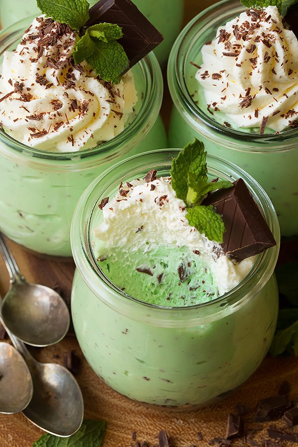 Mint chip cheesecake mousse in a glass jar with a scoop removed to show texture.