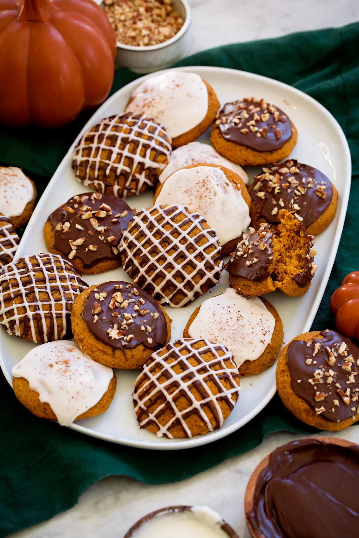 Pumpkin cookies stacked on a serving platter.