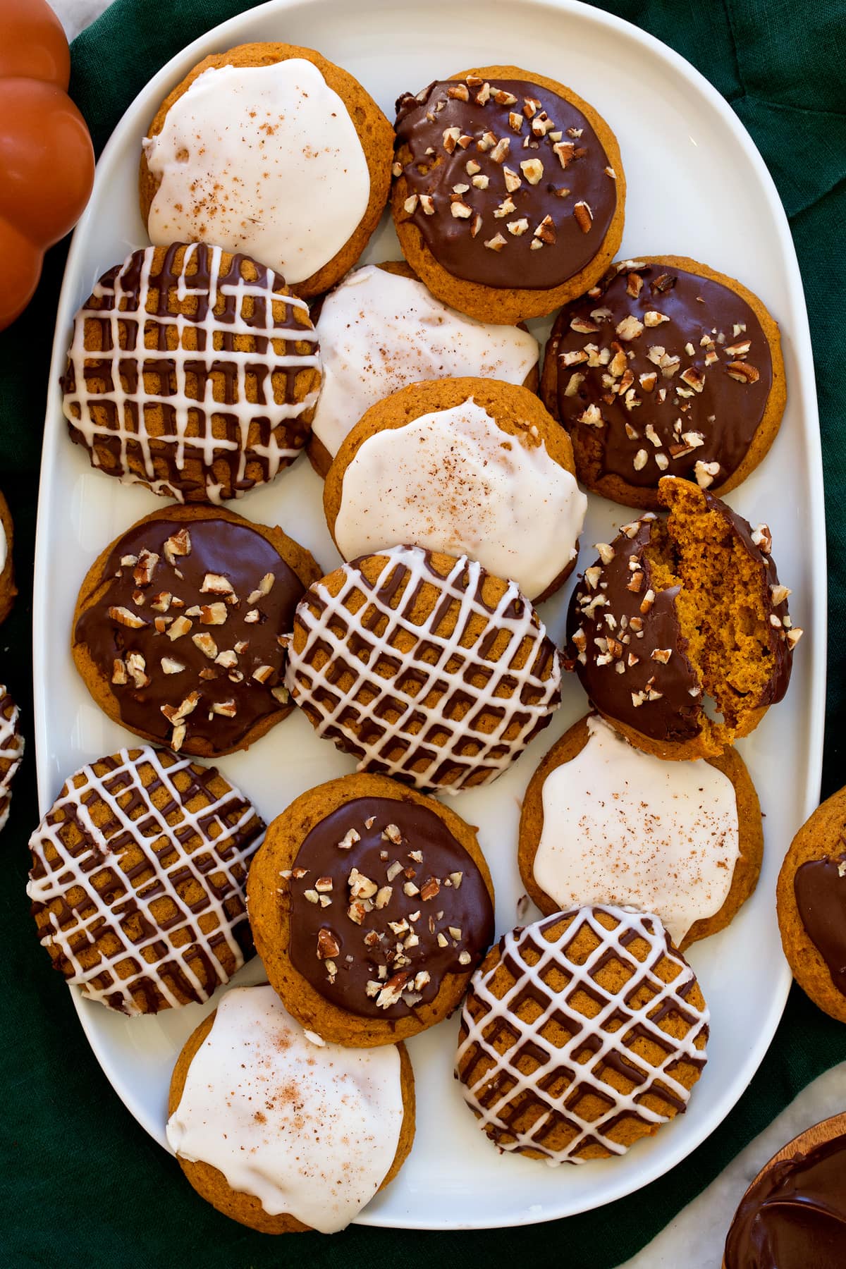 Homemade soft pumpkin cookies with icing shown on a white platter from overhead.
