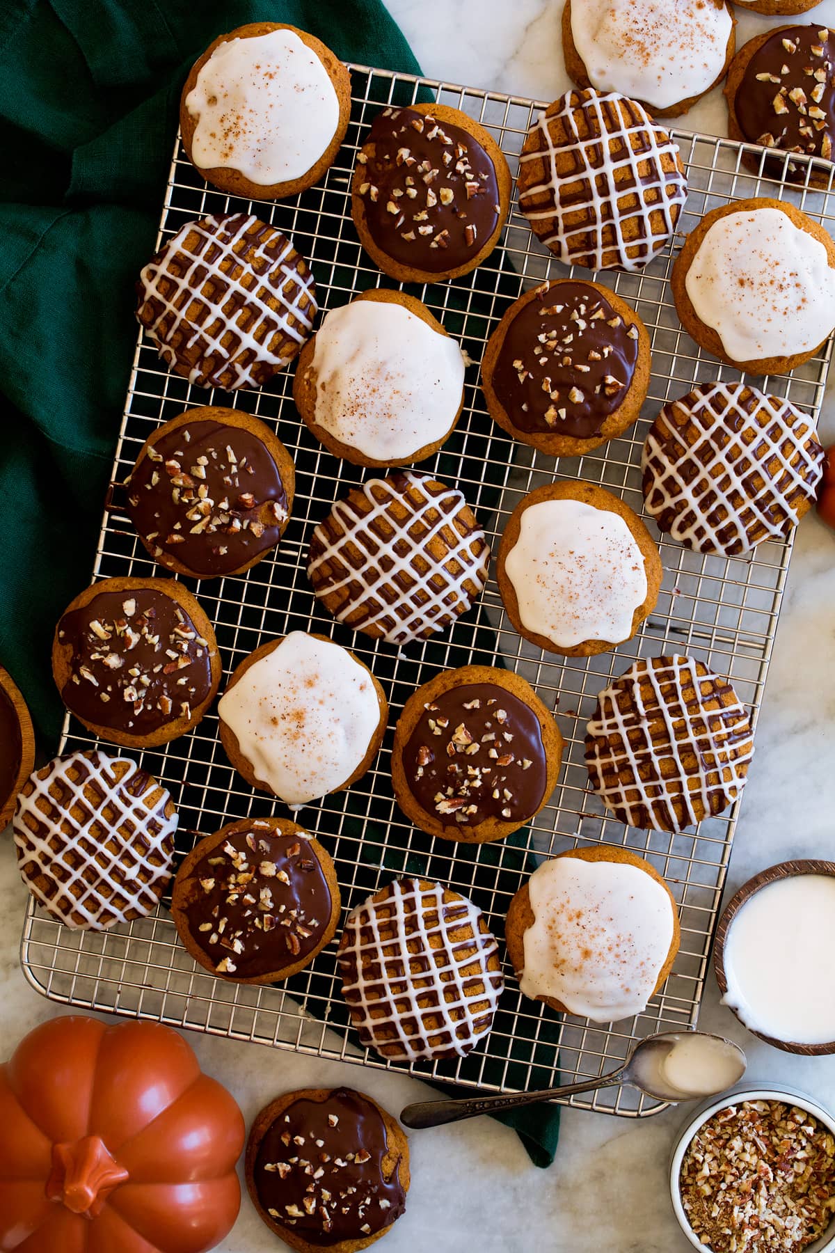 Pumpkin cookies with icing shown on a wire cooling rack.