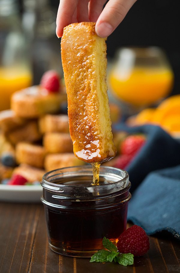 Dipping a French toast stick into jar of syrup