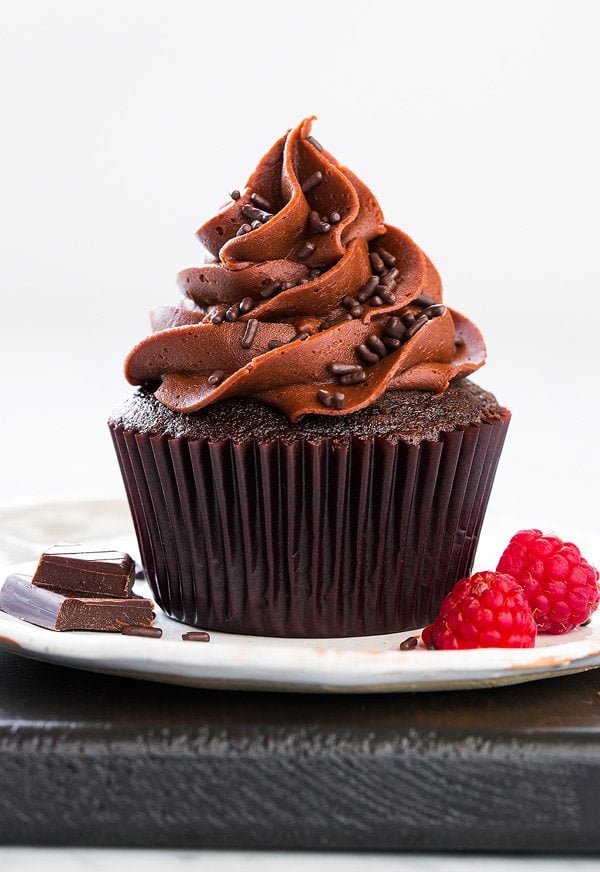 Chocolate cupcake with chocolate frosting and sprinkles on plate 