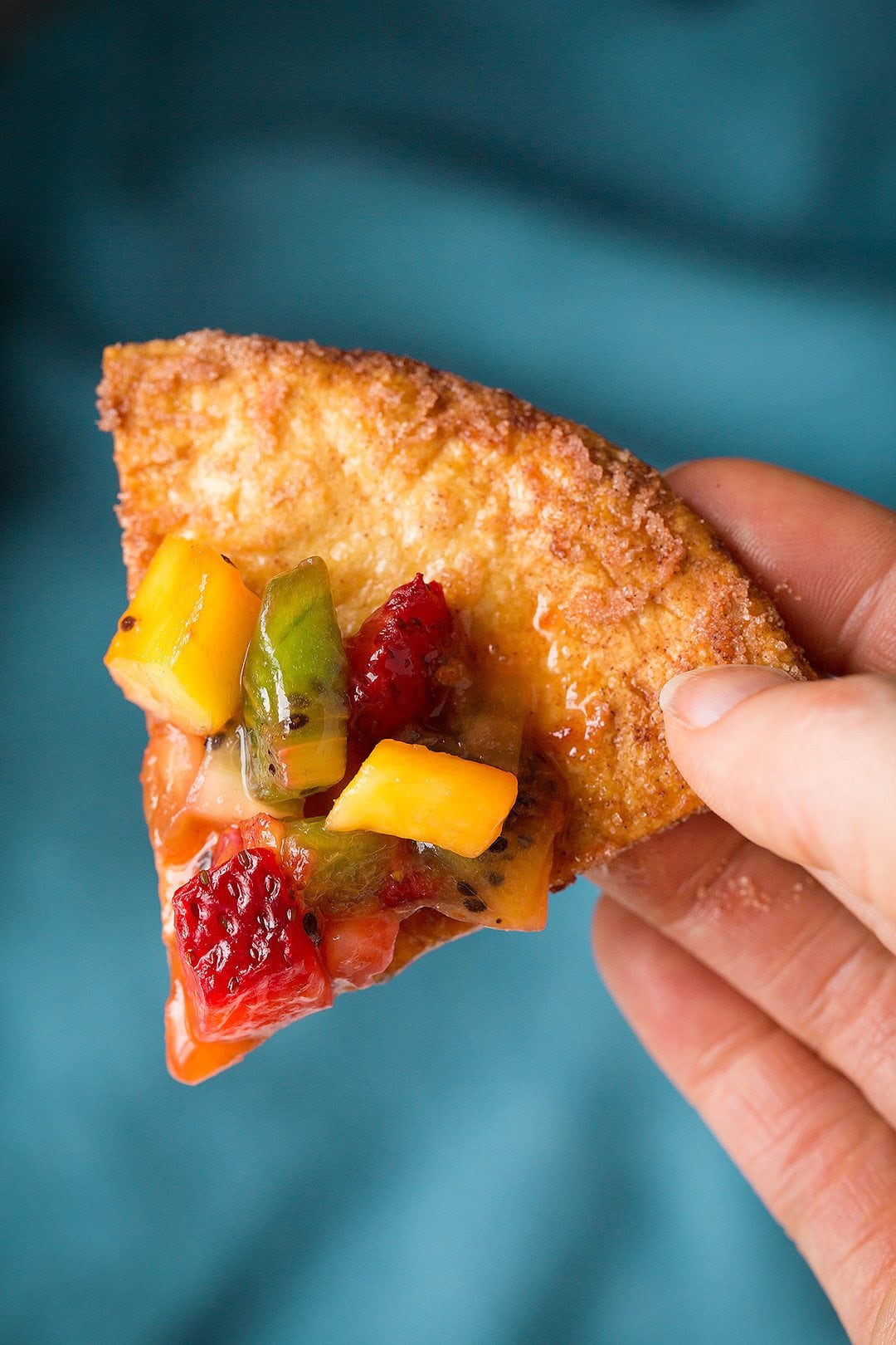 holding a cinnamon chip with fruit salsa