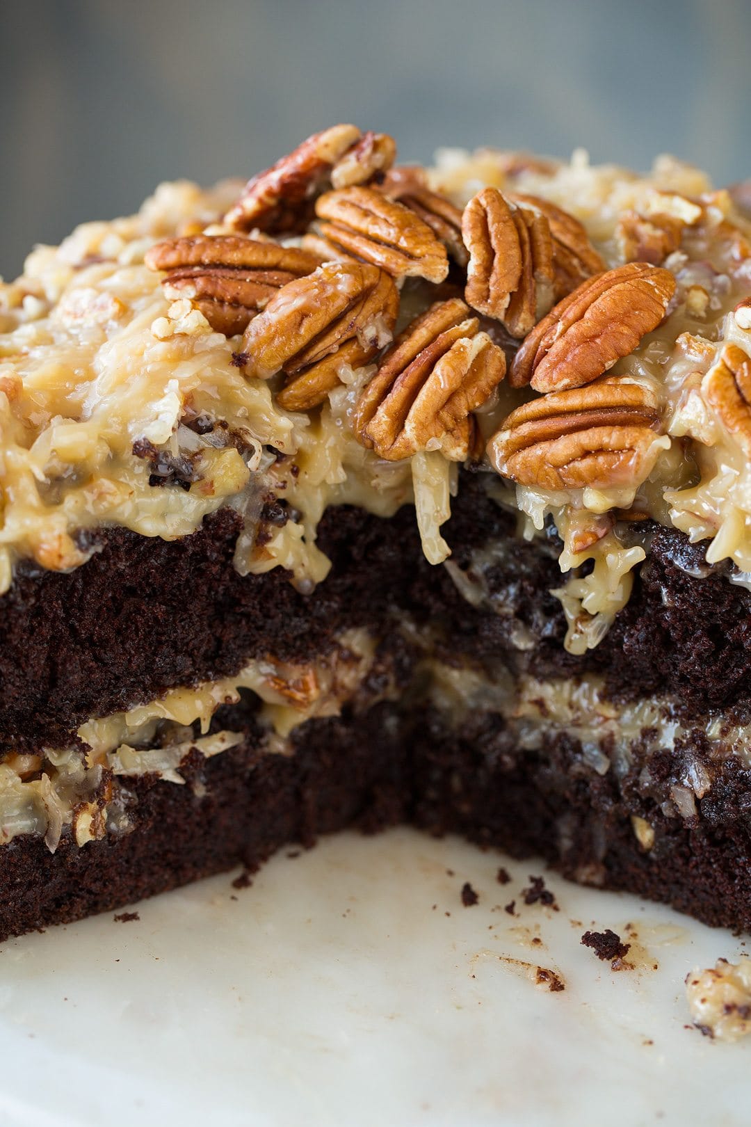 Close up image of German Chocolate Cake showing two chocolate cake layers, and two layers of german chocolate icing made from coconut and pecans.