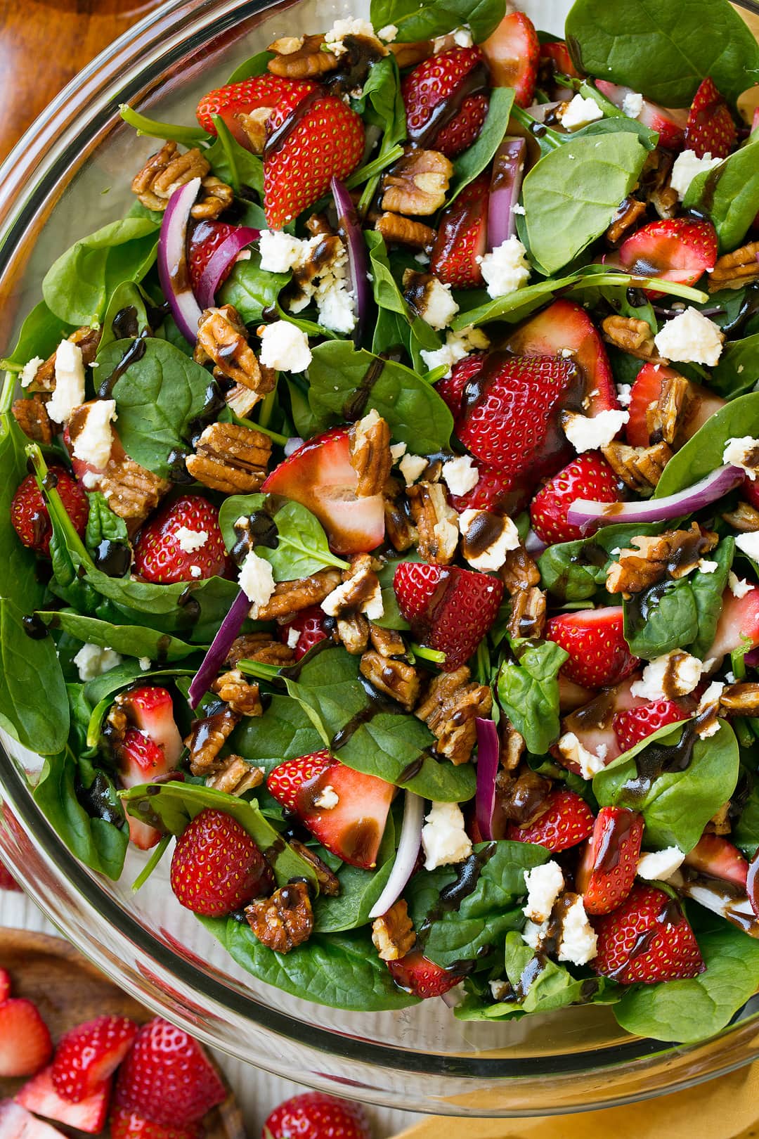 A close up of a Strawberry Spinach Salad drizzled with balsamic