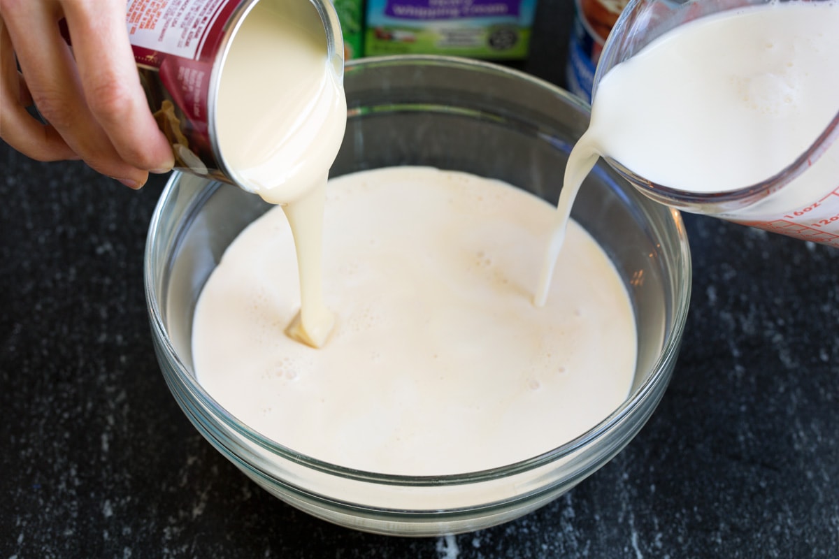 Mixing three milks in a glass mixing bowl.