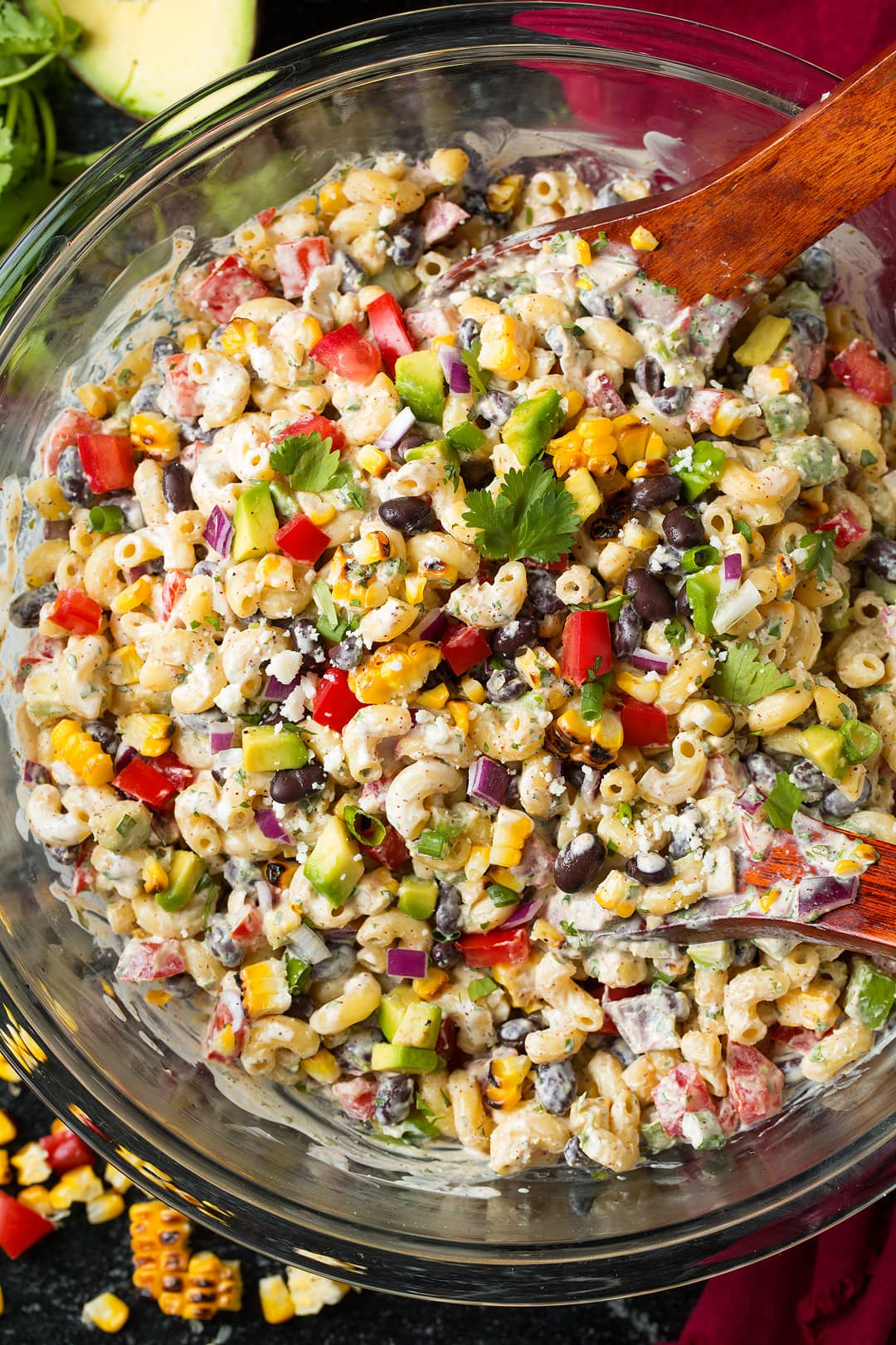 Mexican pasta Salad in glass bowl with wooden spoon