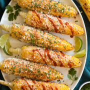 Elotes Grilled Mexican Street corn with cotija cheese, mayo crema, hot sauce and cilantro.