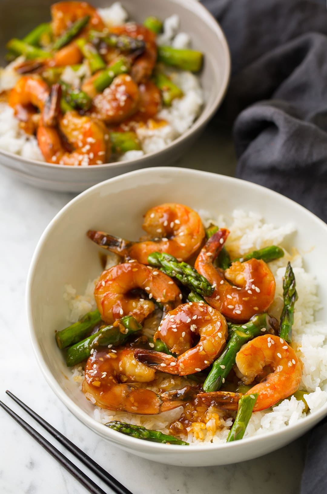 teriyaki shrimp and asparagus in two bowls with rice