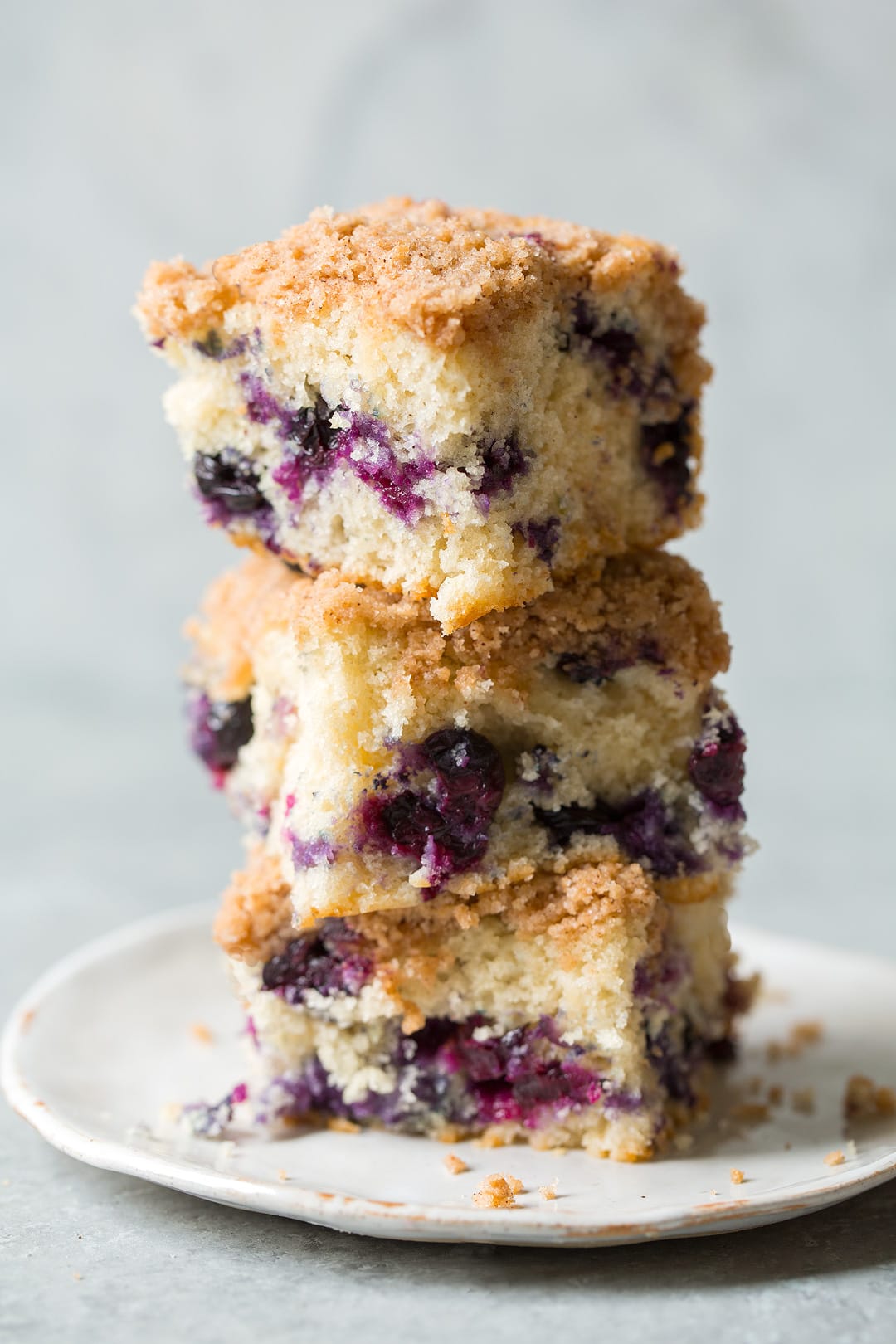 three slices of Blueberry Buckle stacked on top of each other on white plate