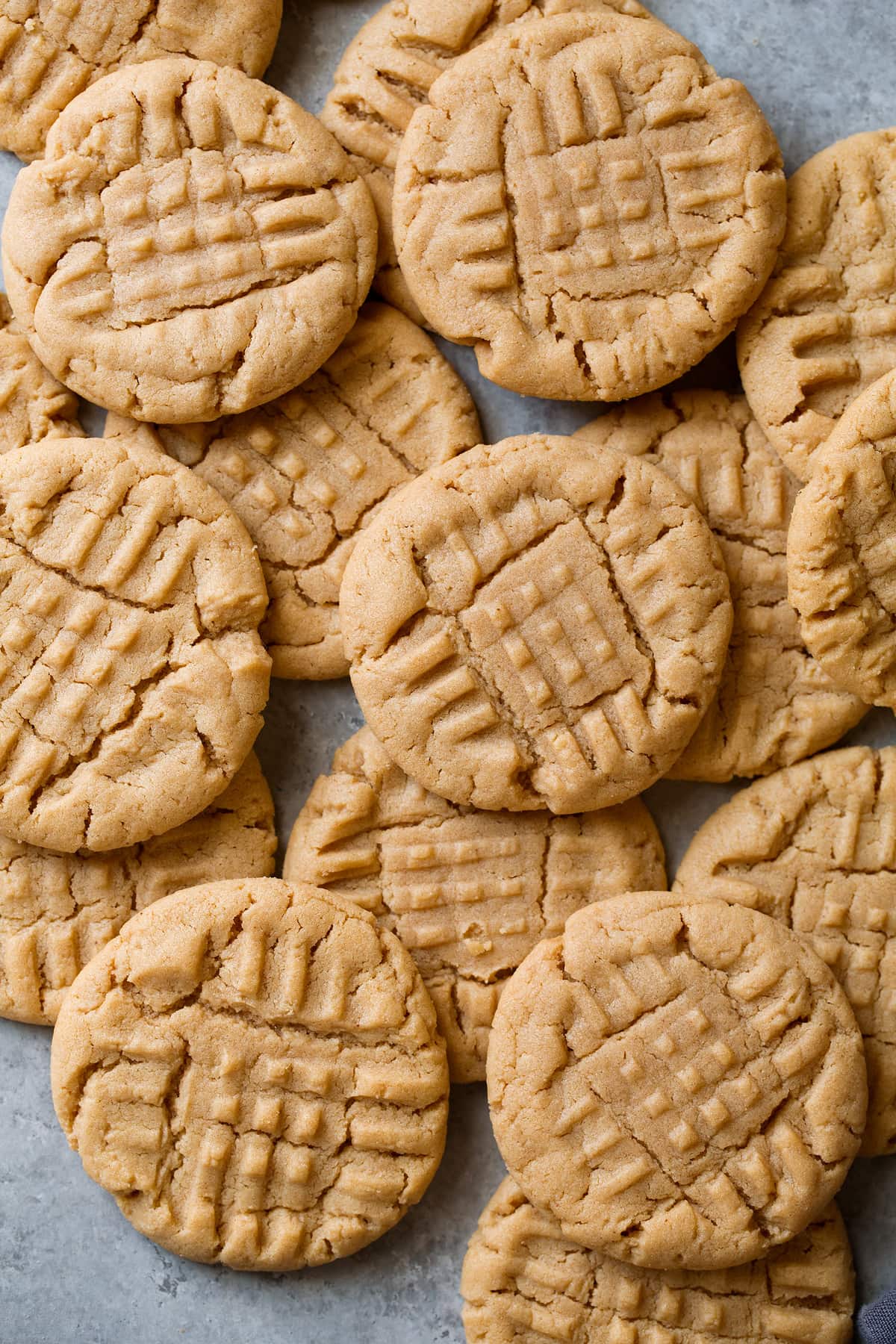 Homemade Peanut Butter Cookies stacked on a grey surface.