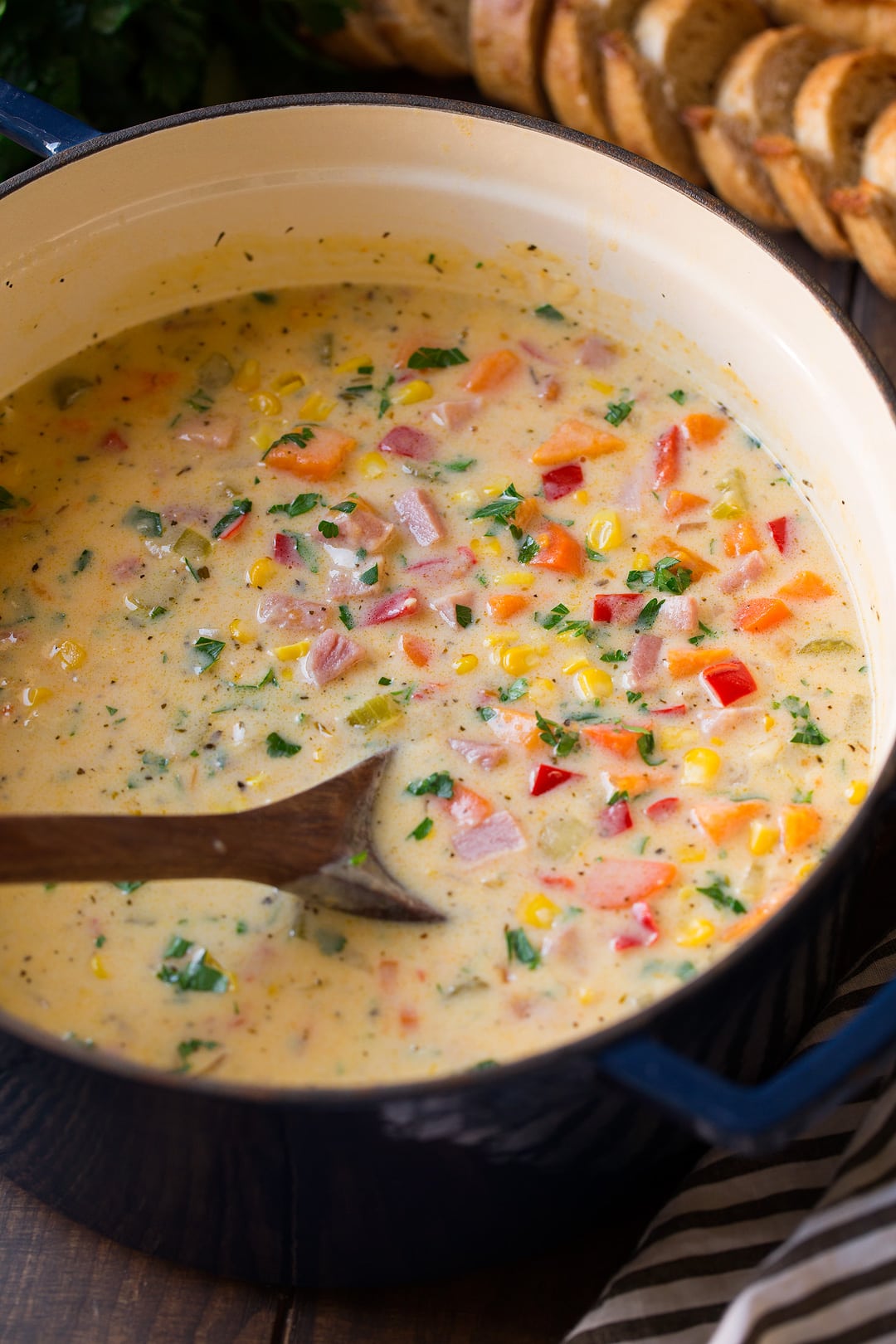 Corn chowder with ham and sweet potatoes in a large navy pot.